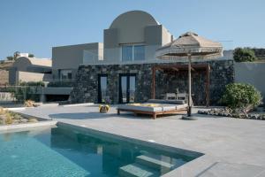 a house with a swimming pool and an umbrella at Melidonia Suites in Akrotiri