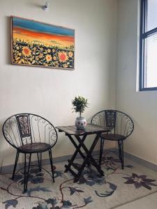 a table with two chairs and a table with a plant on it at The Hp 39 House in Dharmsāla