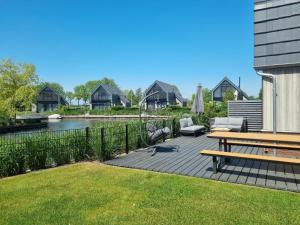 a patio with a table and chairs and a river at Lutz Watervilla's Balk in Balk +39 photos