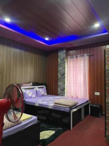 a room with a bed with a fan in it at Paradise Hotel & Lodge in Birtamod