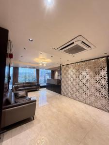a lobby with a waiting area with chairs and a wall at Hotel Presidency - Sosyo Circle in Surat