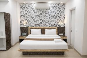 a bedroom with a bed and a black and white wall at Sairaah Golden Suites, Shirdi in Shirdi