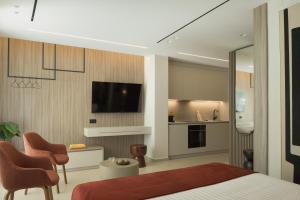 a bedroom with a bed and a kitchen with a tv at Space Row Exclusive Residences in Heraklio