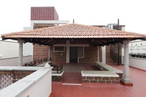 a brick building with a pavilion on a roof at SIENNA Ecr in Chennai