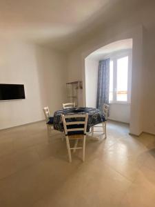 a dining room with a table and chairs and a window at Trame - La Naca sul Porto in Polignano a Mare