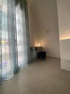 a living room with curtains and a table with a chair at Trame - La Naca sul Porto in Polignano a Mare