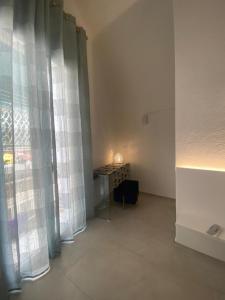 a room with a table and a window with curtains at Trame - La Naca sul Porto in Polignano a Mare +122 photos