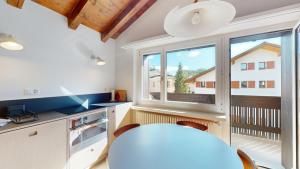 a kitchen with a table and a large window at Chesa Chatrigna App 9 - Celerina in Celerina +19 photos