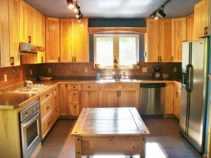 une cuisine avec des placards en bois et une table en bois dans l'établissement The Bear Cabin, à Ironwood