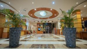 a lobby with palm trees in large vases at Marsa Diba Hotel in Ḑubā +70 photos