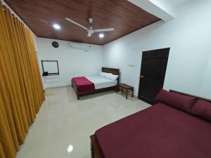a bedroom with a bed and a couch in a room at Galoya Red Lotus in Ampara