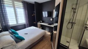a bedroom with a shower and a bed with blue pillows at Be Cottage Hotel in Le Touquet-Paris-Plage +55 photos