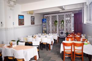 a dining room with white tables and chairs at Diamond Suite Dai Nam Hotel in Can Tho