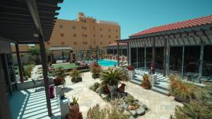 an outdoor patio with a pool and potted plants at Marsa Diba Hotel in Ḑubā