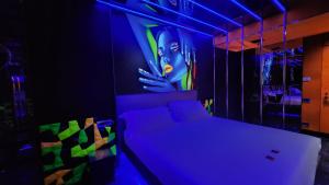 a bedroom with a bed with a painting on the wall at C rooms - Suite a tema con vasca - Motel Monza in Cinisello Balsamo