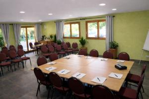 a conference room with a large wooden table and chairs at Logis Hotel Le Lac in Embrun +31 photos
