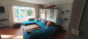 a living room with two blue couches and a table at In the bush in Boknes