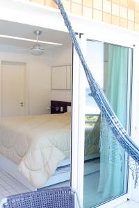 1 dormitorio con 1 cama y puerta de cristal en Camboinhas Oceanside Oceanfront, en Río de Janeiro