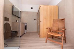a wooden chair in a bathroom with a washing machine at Apartmán Istebné luxure in Istebné +3 photos