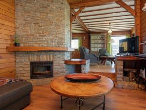 a living room with a fireplace and a table at Vintage Villa with Private Garden in Rendeux in Magoster