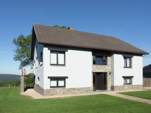 a white house with a black roof at Vintage Villa with Private Garden in Rendeux in Magoster