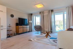 a living room with a couch and a television at Lachmöwe B1-311 mit Meerblick und Balkon in Binz