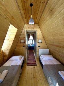 a bedroom with two beds in a wooden house at Take A Brake Kazbegi Cottage in Kazbegi