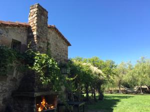 a stone building with a fireplace in a yard at Casa Tejada in Rúerrero +13 photos
