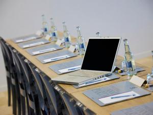a long table with a laptop computer on top of it at Kyriad Prestige Residence & Spa Cabourg-Dives-sur-Mer in Dives-sur-Mer +37 photos