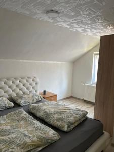 a bedroom with a bed with a white headboard at Domaćinstvo Kondić in Podovi