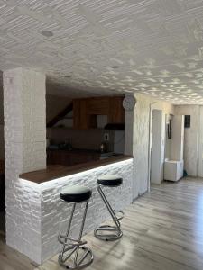 a kitchen with two stools in front of a counter at Domaćinstvo Kondić in Podovi