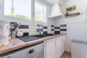 a white kitchen with a sink and a window at Villa de la brune in Bormes-les-Mimosas