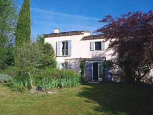 a white house with a tree in a yard at Le Jardin d'Anna in Saint-Eutrope-de-Born