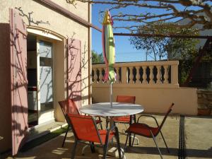 a table with chairs and an umbrella on a patio at Herault Maraussan in Maraussan