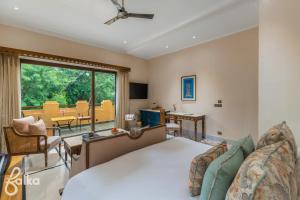a bedroom with a bed and a living room at Dev Bagh Luxurious Private Suites in Debāri