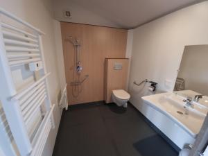 a bathroom with a shower and a toilet and a sink at Camping Les Goélands Carnac in Plouharnel +65 photos
