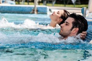 a man and a woman in a swimming pool at Hotel Terme Helvetia in Abano Terme