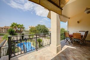 a balcony with a table and chairs and a pool at Capavila by Rentallorca in Muro