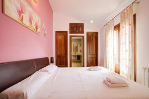 a bedroom with a large bed with pink walls at Capavila by Rentallorca in Muro +18 photos