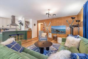 a living room with a green couch and a kitchen at Donner Lake Outpost home in Truckee