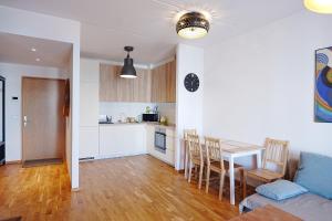 a kitchen and a living room with a table and chairs at Modern apartement with a balcony in Tallinn +5 photos