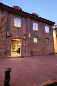 un grand bâtiment en briques avec une grande porte dans l'établissement Hotel A Tafona do Peregrino, à Saint-Jacques-de-Compostelle