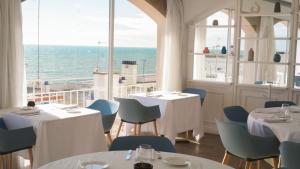 a restaurant with tables and chairs and a view of the ocean at Gran Sol Hotel in San Pol de Mar