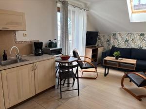 a kitchen and living room with a couch and a table at Apartamenty LeVilla in Rewa
