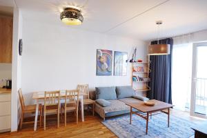 a living room with a couch and a table at Modern apartement with a balcony in Tallinn