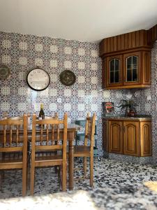 a kitchen with a table and a clock on the wall at CASA LUMERMA in Taboadela