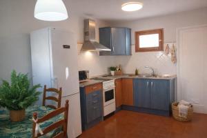 a kitchen with blue cabinets and a white refrigerator at El Molino Agaete in Puerto de las Nieves
