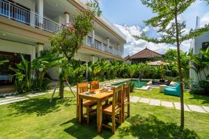 a dining table in the backyard of a house at Maha Prana Kedungu by Aayan in Tanah Lot