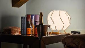 a table with a bottle of wine and a lamp at B&b Ca'Baracca Bellavista in Bassano del Grappa