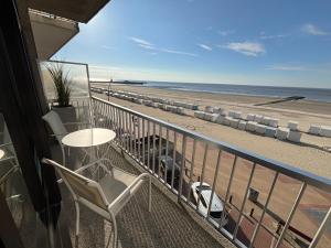 a balcony with a table and chairs and the beach at Orion NorthSea Suite in Blankenberge
